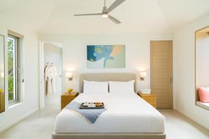 - une chambre avec un grand lit blanc et une fenêtre dans l'établissement Rock House, à Providenciales