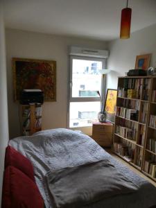 - une chambre avec un lit et une étagère avec des livres dans l'établissement Lovely room in quiet appartment, à Ivry-sur-Seine