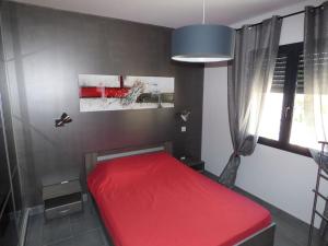 Olmeta-di-Tuda的住宿－Tout confort pour explorer la Haute Corse，窗户客房内的一张红色的床