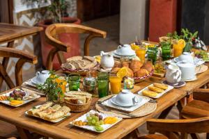 einem Holztisch mit Frühstücksspeise darauf in der Unterkunft Riad Ambre et Jasmin in Marrakesch