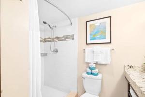 een witte badkamer met een douche en een toilet bij Modern Luxury Large Studio in Honolulu
