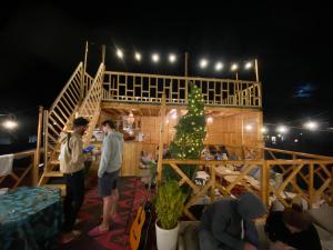 un grupo de personas de pie alrededor de una habitación con un árbol de Navidad en West coast surf house, en Imsouane