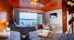 1 Schlafzimmer mit 2 Betten und Blick auf das Wasser in der Unterkunft Destinar Apartments in San Carlos de Bariloche