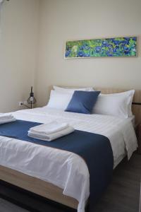 a large white bed with blue and white pillows at Dafni City Apartment 3 in Athens