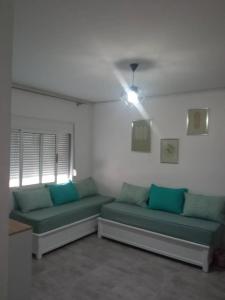 una sala de estar con 2 sofás verdes y una ventana en Sweet 2 rooms accommodation, en Birkhadem