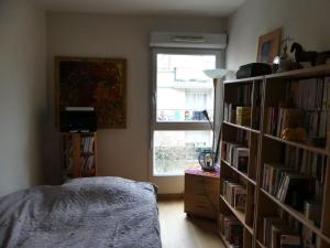 une chambre avec une étagère remplie de livres dans l'établissement Lovely room in quiet appartment, à Ivry-sur-Seine