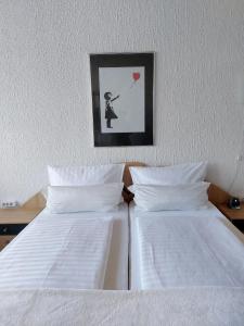 a bedroom with two beds with a picture of a woman holding a heart at Pension Forstgut Waldeck in Ingelheim am Rhein