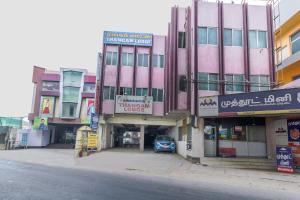 a pink building on the side of a street at Thangam Lodge in Coimbatore