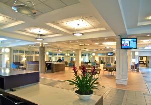 a large lobby with tables and chairs and a television at The Golden Jubilee Hotel in Clydebank