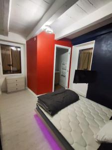 Cama en habitación con paredes rojas y azules en jolie petite maison de bourg en Sayat