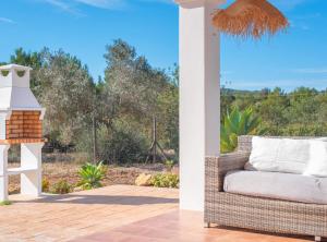 a wicker chair on a patio with a view of a yard at Villa Sa Planeta in Sant Josep de Sa Talaia