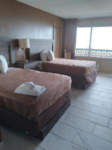 a hotel room with two beds and a balcony at The Virginian Motel in Myrtle Beach