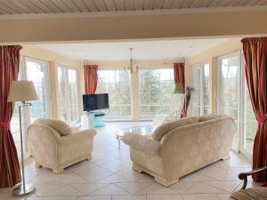 salon z 2 krzesłami i telewizorem w obiekcie Villa Recknitztal Marlow w mieście Marlow