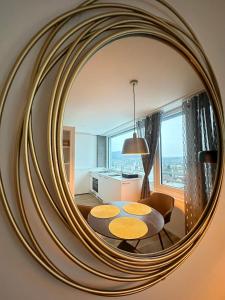 MydiHei @ Rhyfall Towers في نيوهاسن ام رينفا: مرآة في غرفة المعيشة مع طاولة وكراسي