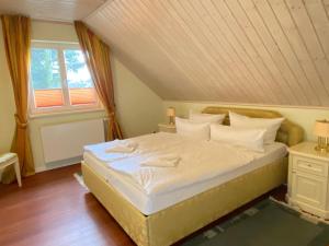 sypialnia z dużym łóżkiem na poddaszu w obiekcie Villa Recknitztal Marlow w mieście Marlow
