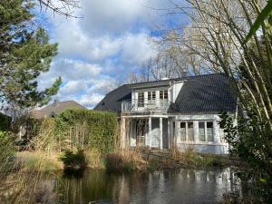 a house sitting next to a body of water at Villa Recknitztal Marlow in Marlow