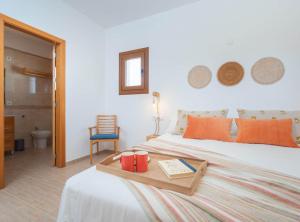 a bedroom with a bed with two red cups on a tray at Villa Sa Planeta in Sant Josep de Sa Talaia +31 photos