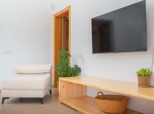 a living room with a tv on a wall at Villa Sa Planeta in Sant Josep de Sa Talaia