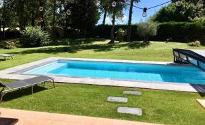 una piscina en el césped con un banco al lado en Les clés de Jonzac-concergerie La renardière 8 personnes en Touvérac