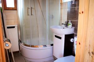 a small bathroom with a shower and a sink at Domki Wypoczynkowe Letnia Przygoda in Mielno