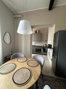 a dining room table with chairs and a kitchen at Room Manzoni 37 in Cremona +20 photos