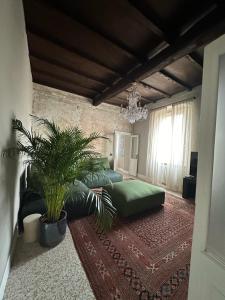 ein Wohnzimmer mit einem Sofa und einem Kronleuchter in der Unterkunft Room Manzoni 37 in Cremona