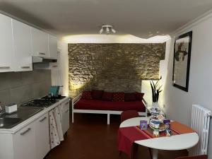 貝內文托的住宿－Domus Isidis room camera singola con cucina，厨房以及带红色沙发的起居室。
