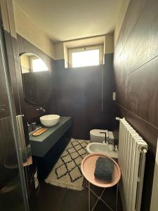 een badkamer met een wastafel, een toilet en een spiegel bij Room Manzoni 37 in Cremona