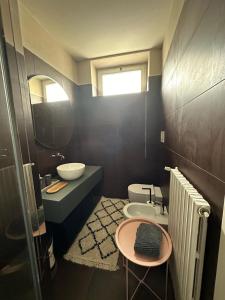 a bathroom with a sink and a toilet and a mirror at Room Manzoni 37 in Cremona