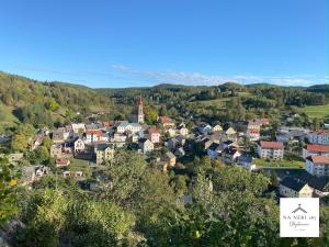 uma vista aérea de uma pequena cidade nas colinas em Na Nebi 187 em Becov nad Teplou