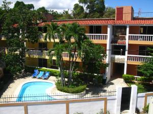 an aerial view of a hotel with a pool and palm trees at Sosua Suites Condos in Sosúa