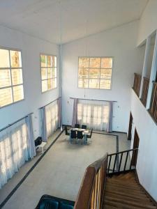 a large room with windows and a table and chairs at La Maison Blanche in Bafoussam