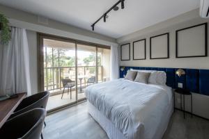 a bedroom with a large bed and a balcony at Charlie On The Parc Ibirapuera Hotel in Sao Paulo