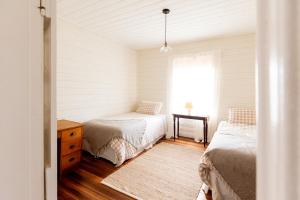 ein Schlafzimmer mit zwei Betten und einem Fenster in der Unterkunft Falmouth Cottage - Dog Friendly Beachside Getaway 2,5 Acres in Falmouth