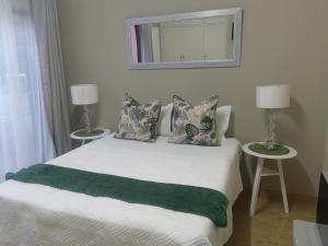 sypialnia z łóżkiem z 2 stołami i lustrem w obiekcie Zhantique Guest House Unit 5 w mieście Boksburg