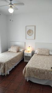 um quarto com 2 camas e uma mesa com um candeeiro em CASA MAR em Vélez-Málaga