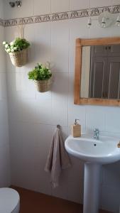 uma casa de banho com um lavatório, um espelho e um WC. em CASA MAR em Vélez-Málaga
