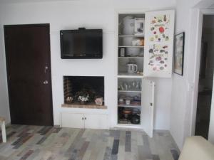 a living room with a fireplace and a tv on the wall at Meridien Excelete Depertamento! in Punta del Este