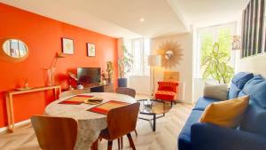 尼奧爾的住宿－Votre Escale - Magellan Cinéma，客厅配有桌子和蓝色沙发