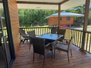 a patio with a table and chairs on a deck at Parea Lodge Huahine Bungalow 3#Ava'e in Parea
