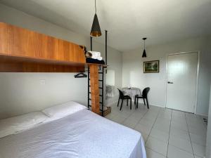 1 dormitorio con 1 cama y 1 mesa con sillas en Loft funcional no centro!, en Foz do Iguaçu