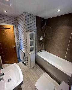 a bathroom with a tub and a toilet and a sink at 5 Riverside Place Thurso. 2 bed, 2 bathrooms. in Thurso