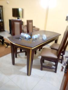 a wooden table with chairs and a dining room at ROYAL HOUSE INTERNATIONAL in Porto-Novo