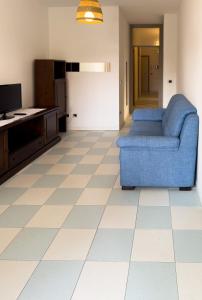 sala de estar con sofá azul y suelo de baldosa en Marina Beach Escape, en Marina di Ravenna