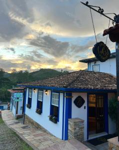 a blue and white house with a pumpkin on the roof at Pousada Sinhá Olímpia in Ouro Preto