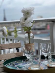 un jarrón lleno de flores blancas sentado en una mesa en Garden Eiffel Tower - Paris Expo Porte de Versailles, en Issy-les-Moulineaux