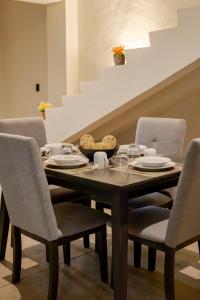 uma sala de jantar com uma mesa de madeira e cadeiras em Casa Kuxul em Mérida