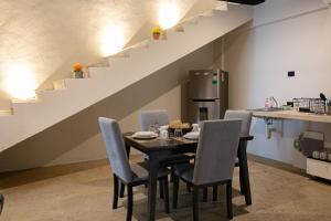 uma sala de jantar com mesa, cadeiras e escadas em Casa Kuxul em Mérida