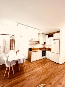 una cucina con tavolo bianco e armadietti bianchi di Boo_Apartment a Durrës
