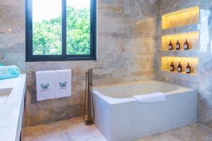 La salle de bains est pourvue d'une baignoire et d'une fenêtre. dans l'établissement IDA B Domain, à Nathon Bay